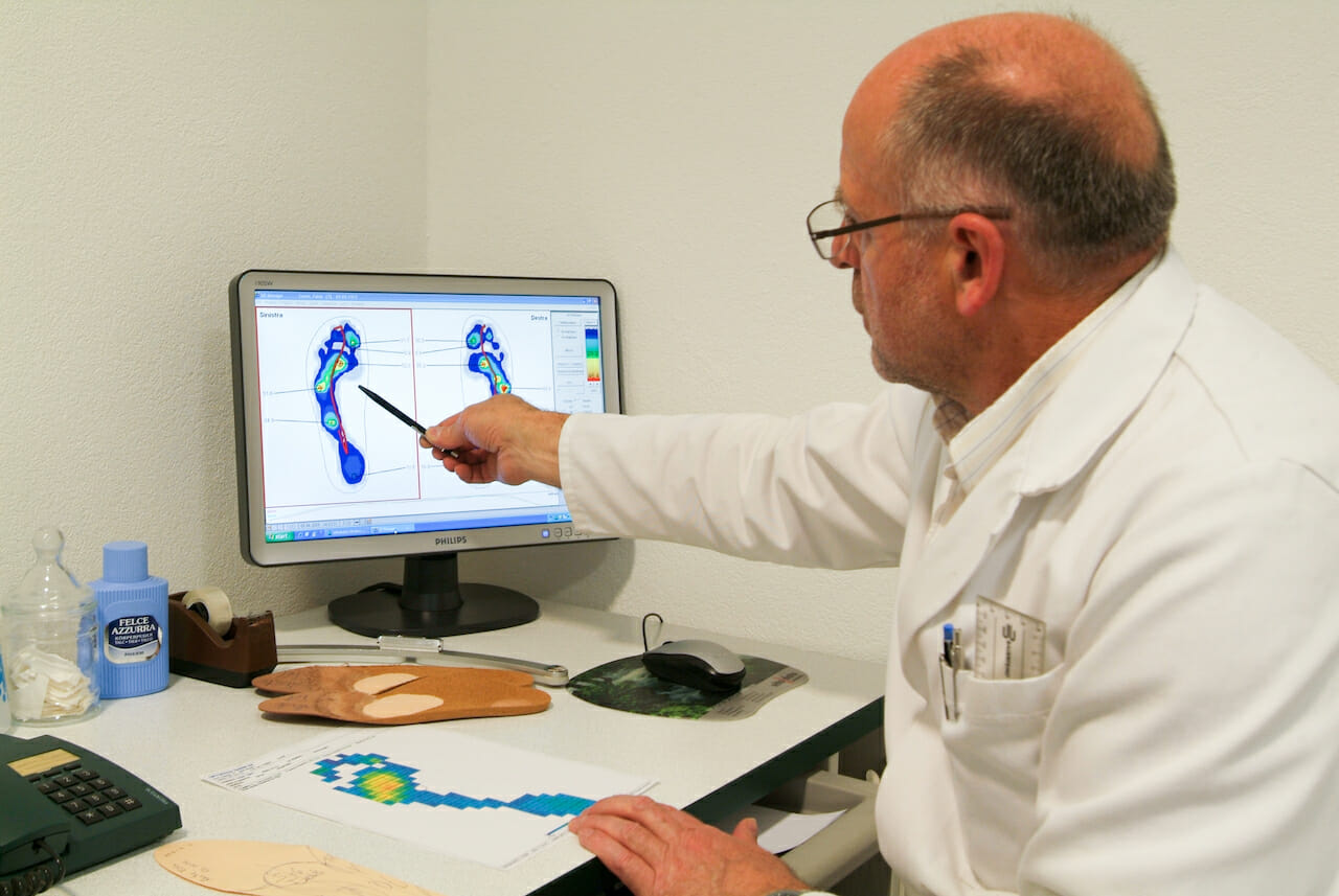 Doctor preparing orthopedic insoles for a patient on his studio