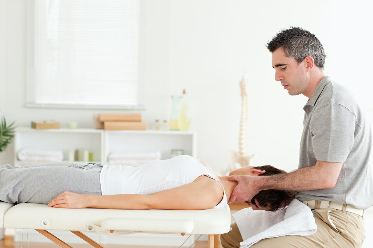 Chiropractor massaging woman's neck